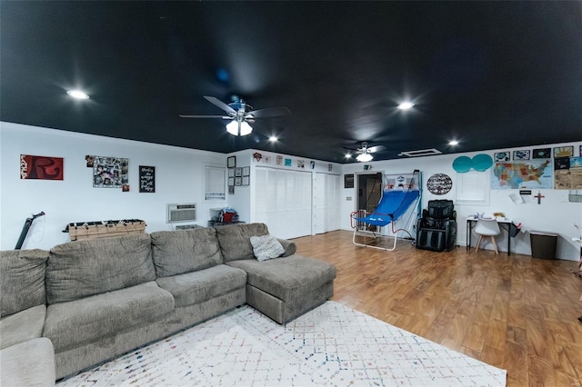 living room featuring ceiling fan, a wall unit AC, wood finished floors, and recessed lighting