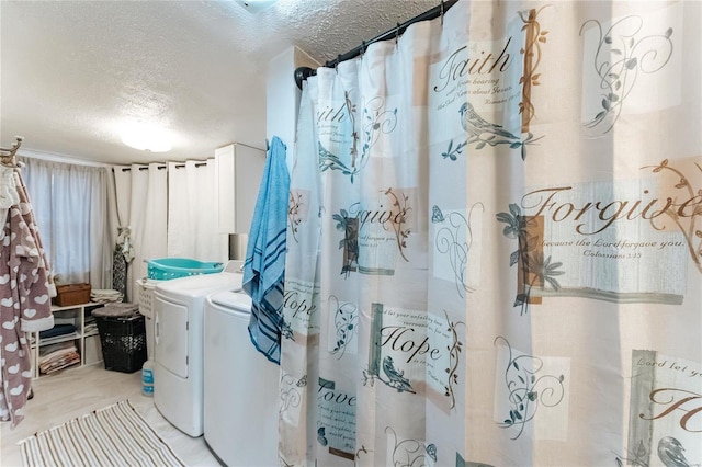 clothes washing area with laundry area, a textured ceiling, and separate washer and dryer