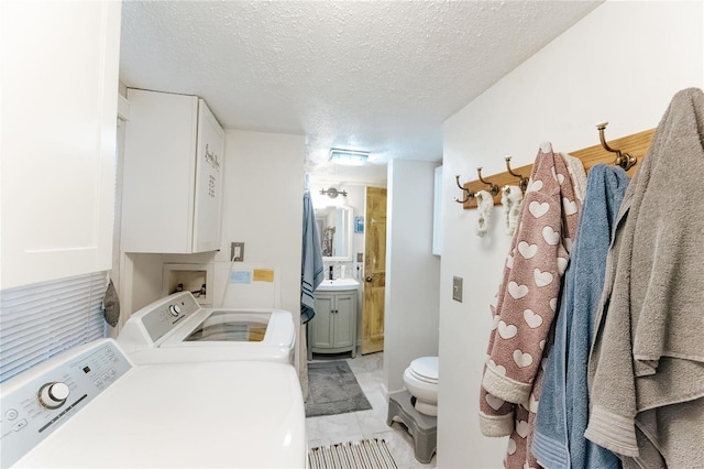 laundry room with a sink, laundry area, a textured ceiling, and independent washer and dryer