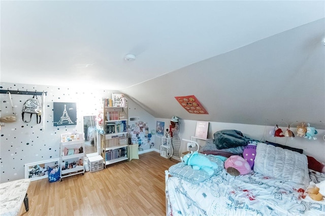 bedroom with vaulted ceiling and wood finished floors