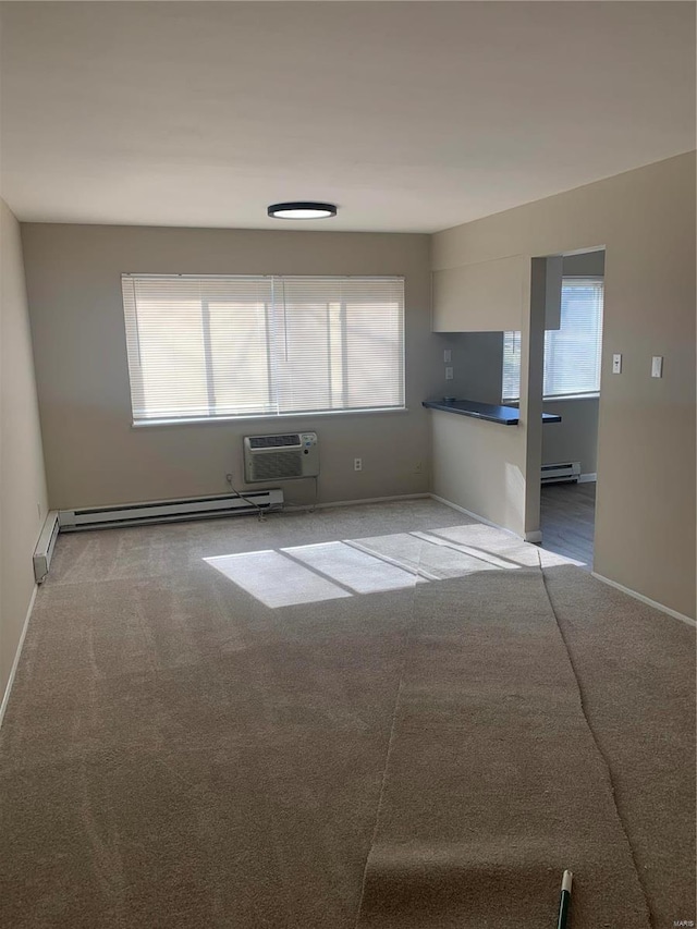 carpeted spare room featuring a wall unit AC, baseboard heating, and a wealth of natural light