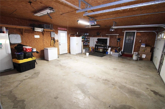 garage featuring refrigerator, washer / clothes dryer, freestanding refrigerator, and a garage door opener