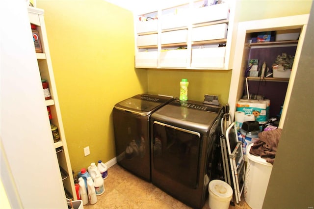 clothes washing area featuring laundry area, independent washer and dryer, and baseboards