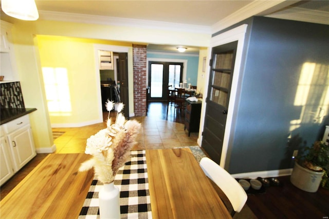 interior space with dark countertops, baseboards, white cabinetry, and crown molding