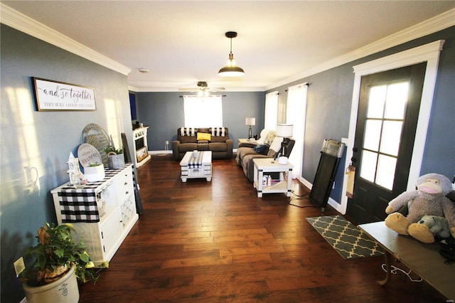 living area with a fireplace, crown molding, dark wood-type flooring, a ceiling fan, and baseboards