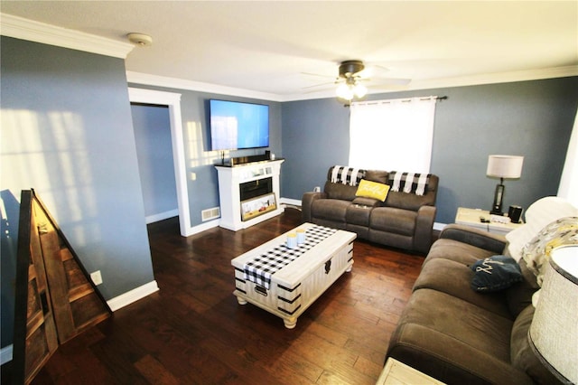 living area featuring ornamental molding, wood finished floors, a glass covered fireplace, and baseboards