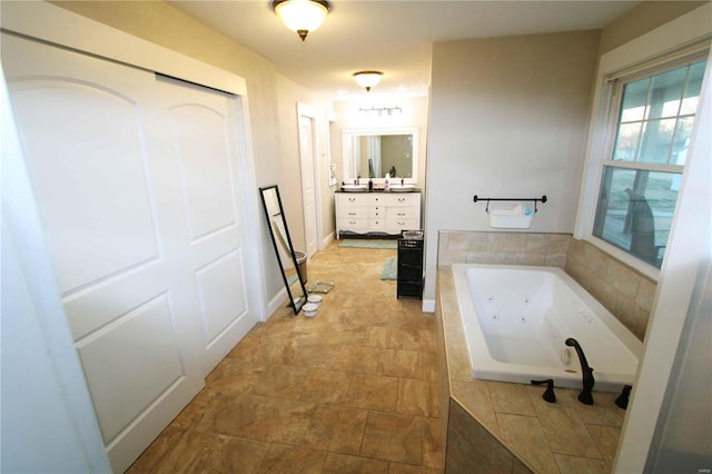 bathroom featuring baseboards, vanity, and a whirlpool tub