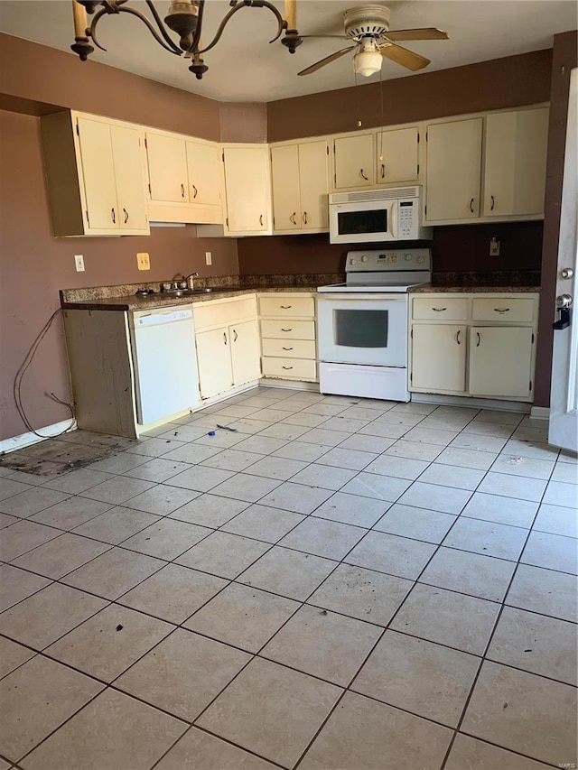 kitchen featuring light tile patterned floors, white appliances, dark countertops, and ceiling fan