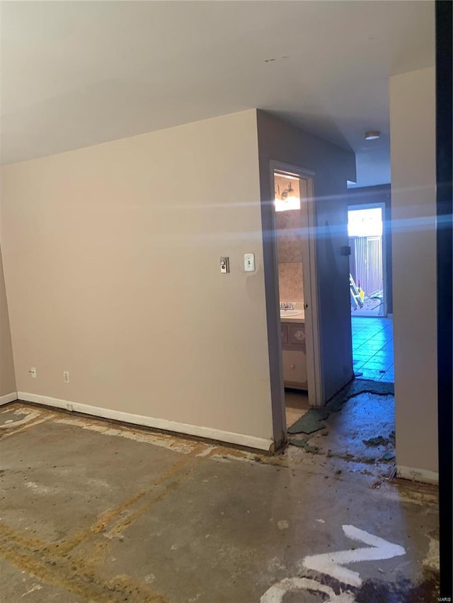 interior space featuring baseboards and a sink