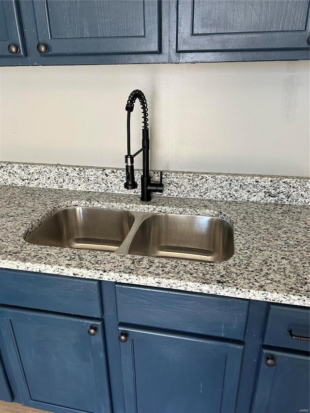 room details with blue cabinetry and a sink