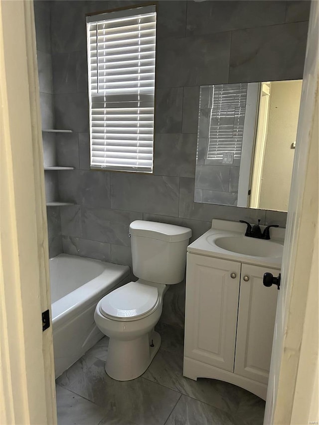 full bathroom with marble finish floor, vanity, toilet, and tile walls