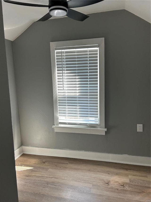 unfurnished room featuring lofted ceiling, wood finished floors, a ceiling fan, and baseboards