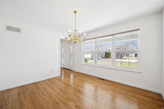 unfurnished dining area featuring a notable chandelier, visible vents, and light wood finished floors