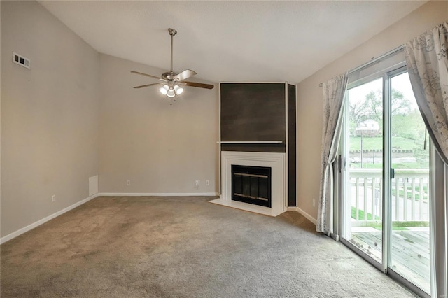 unfurnished living room with carpet floors, visible vents, a fireplace, and baseboards