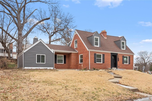 cape cod house featuring a front yard, a shingled roof, a chimney, and brick siding