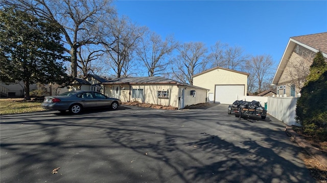 exterior space featuring a garage, an outdoor structure, and fence