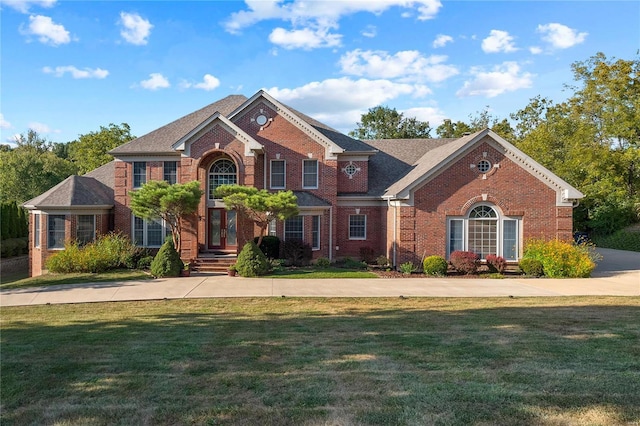 view of front of property with french doors, brick siding, and a front yard