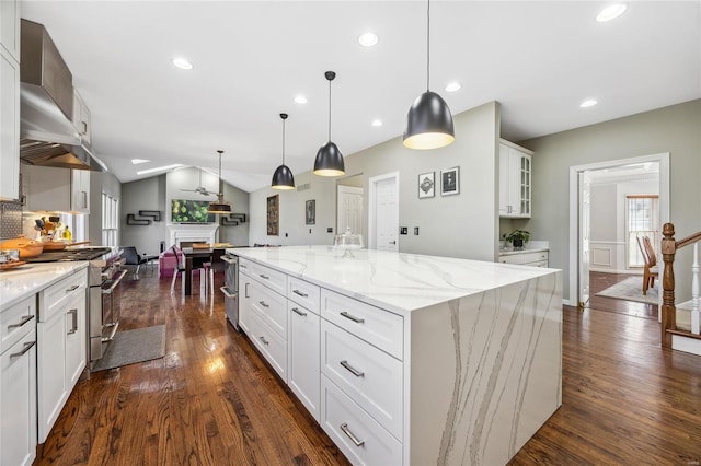 kitchen with dark wood-style floors, a fireplace, vaulted ceiling, and stainless steel stove