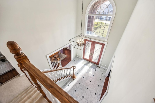 entryway featuring a notable chandelier, baseboards, and stairs