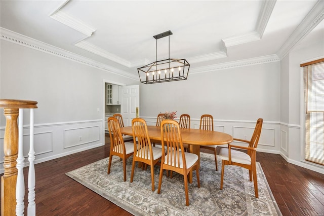 dining space featuring dark wood-style floors, a notable chandelier, a raised ceiling, and crown molding