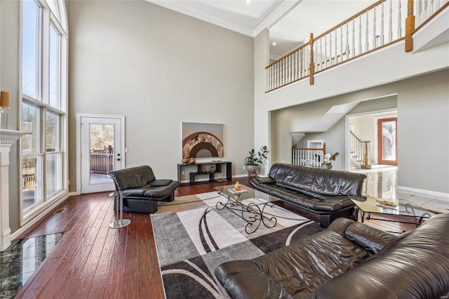 living area featuring stairs, a fireplace, hardwood / wood-style flooring, and baseboards