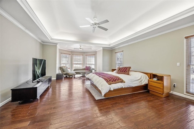 bedroom featuring baseboards, a raised ceiling, hardwood / wood-style flooring, ceiling fan, and crown molding