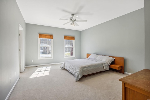 bedroom featuring a ceiling fan, light colored carpet, visible vents, and baseboards