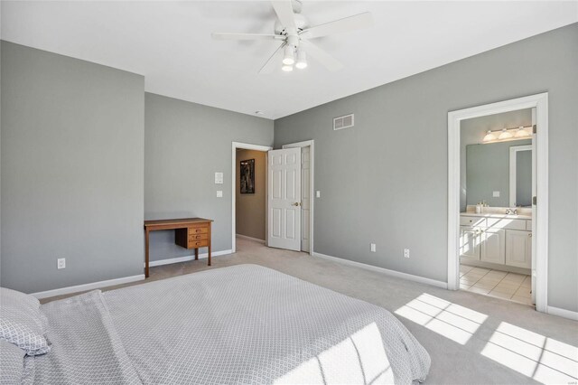 bedroom featuring light carpet, baseboards, visible vents, a ceiling fan, and connected bathroom