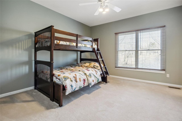 carpeted bedroom featuring ceiling fan, visible vents, and baseboards