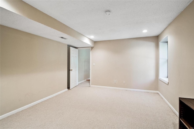 carpeted empty room featuring a textured ceiling, recessed lighting, visible vents, and baseboards