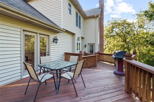 wooden terrace featuring outdoor dining area and grilling area