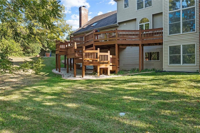 rear view of house with a yard, a chimney, and a wooden deck