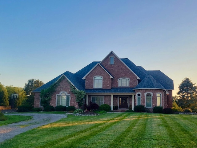 view of front of property featuring a yard and brick siding