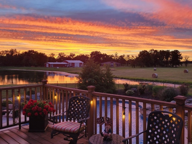 wooden deck with a water view and fence