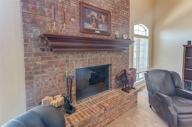 carpeted living room with a brick fireplace