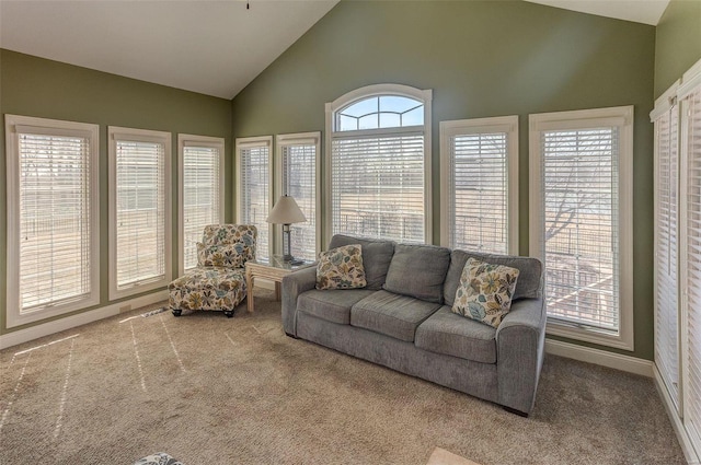 living room with carpet, baseboards, and high vaulted ceiling