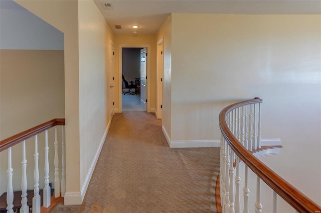 corridor featuring visible vents, carpet flooring, an upstairs landing, and baseboards