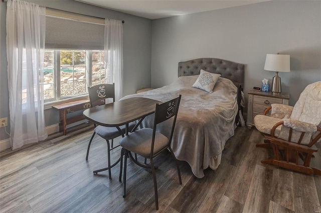 bedroom with baseboards and wood finished floors