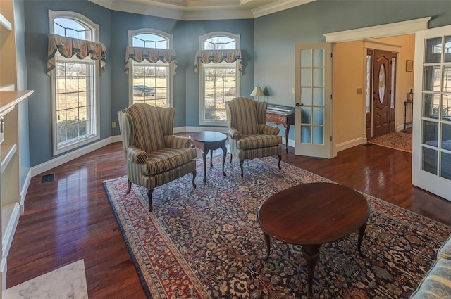 living area with baseboards, wood finished floors, and crown molding