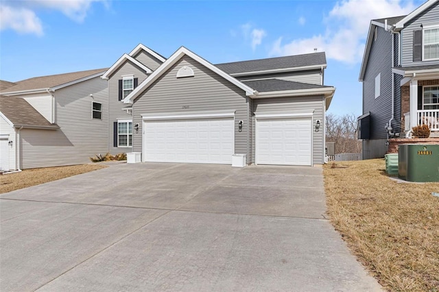 view of front of home with a garage, concrete driveway, and roof with shingles