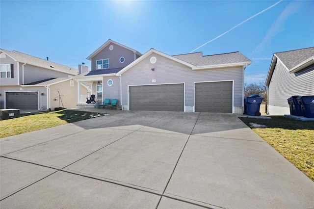 traditional home featuring a garage, concrete driveway, and a front yard