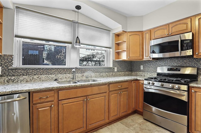 kitchen with light stone counters, a sink, appliances with stainless steel finishes, brown cabinets, and open shelves