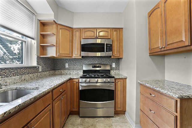 kitchen with appliances with stainless steel finishes, brown cabinets, decorative backsplash, and light stone countertops