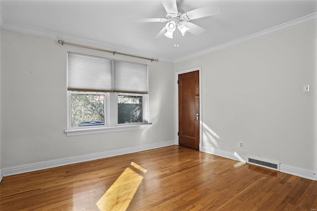 unfurnished room featuring visible vents, crown molding, baseboards, and wood finished floors