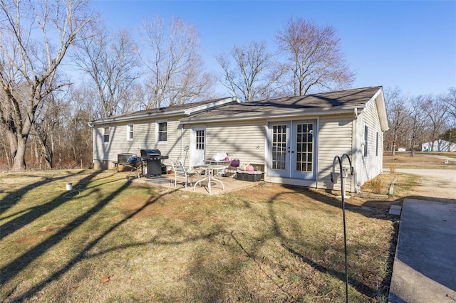 rear view of property with french doors, a lawn, and a patio area