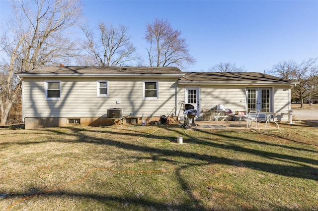 rear view of property featuring french doors, a patio area, a lawn, and central AC unit