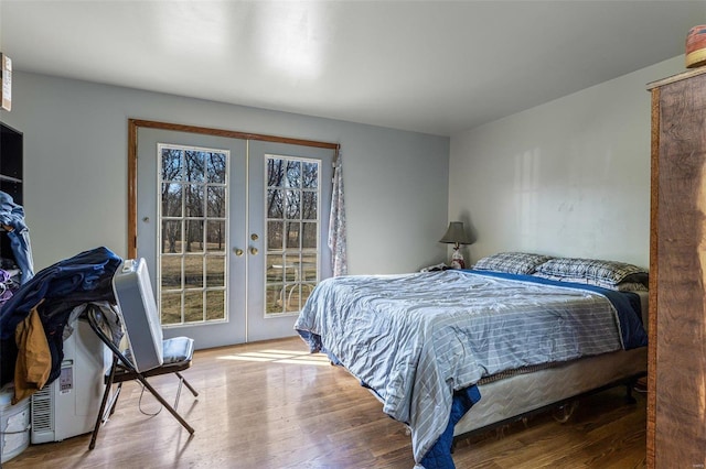 bedroom featuring french doors, wood finished floors, and access to exterior