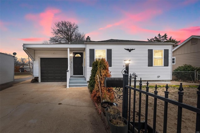 view of front of property with concrete driveway, fence, and an attached garage