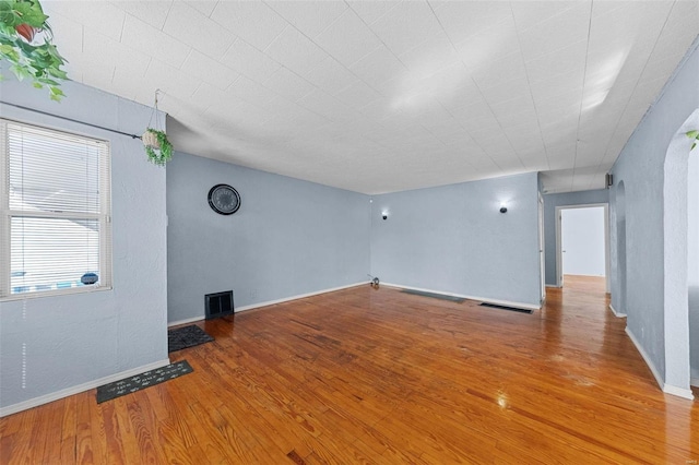 interior space featuring baseboards, visible vents, and wood finished floors