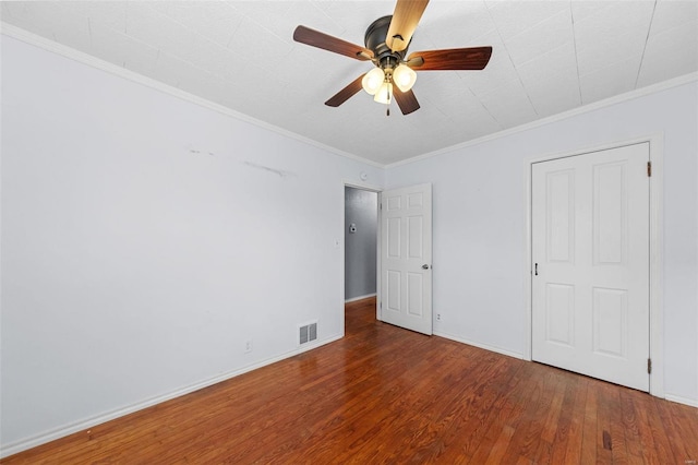 unfurnished bedroom featuring wood finished floors, a ceiling fan, visible vents, baseboards, and ornamental molding